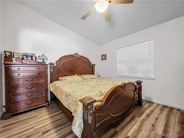 bedroom with a textured ceiling, light hardwood / wood-style flooring, and ceiling fan