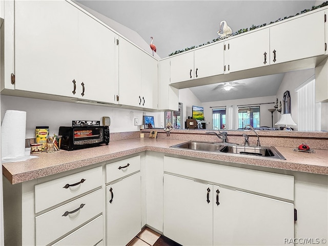 kitchen featuring white cabinets, ceiling fan, lofted ceiling, and sink