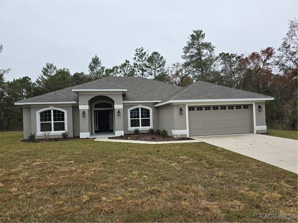 ranch-style home with a garage and a front yard