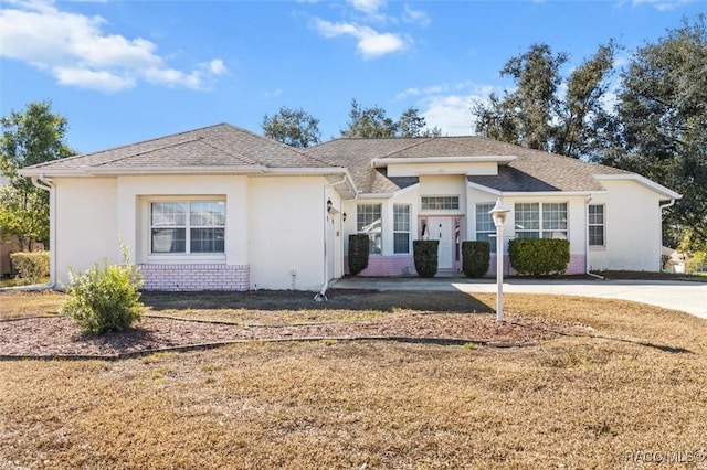 330 W Hillmoor Ln, Beverly Hills, FL 34465 - view of front of home featuring brick siding, stucco siding, a front lawn, and roof with shingles