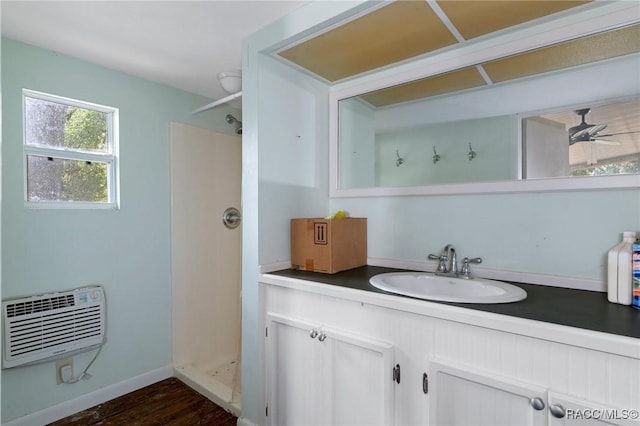 bathroom featuring ceiling fan, hardwood / wood-style floors, vanity, an AC wall unit, and walk in shower