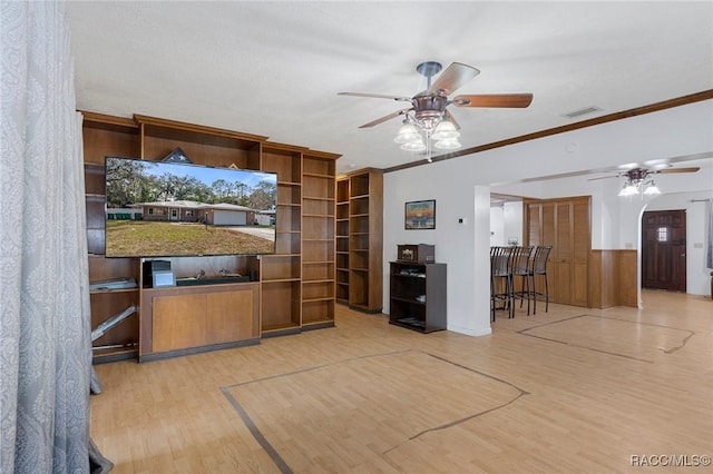 interior space with hardwood / wood-style flooring, ornamental molding, and ceiling fan