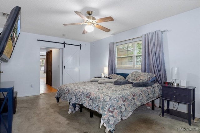 bedroom with a barn door, concrete floors, and ceiling fan