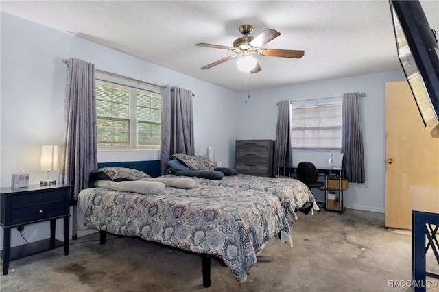 bedroom featuring ceiling fan, concrete flooring, and a textured ceiling