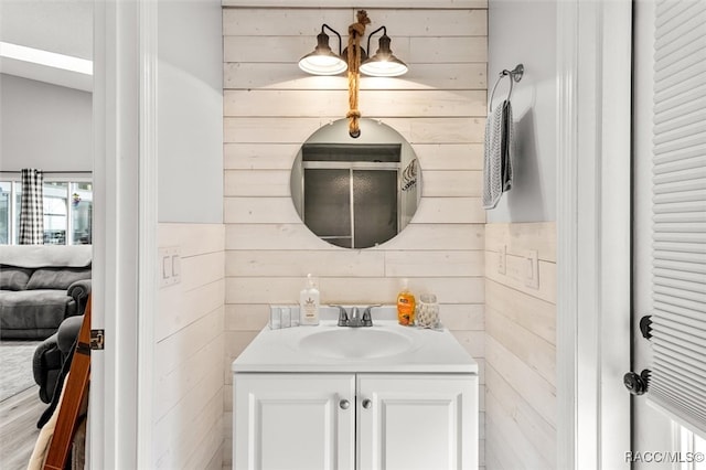 bathroom featuring wood walls and vanity