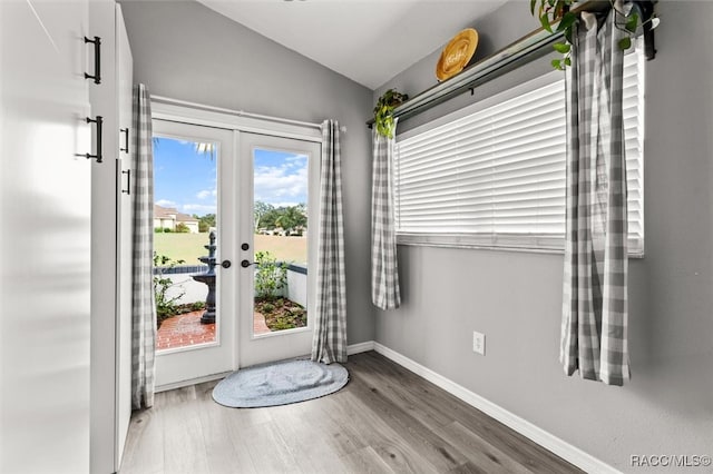 doorway to outside with hardwood / wood-style floors, lofted ceiling, and french doors