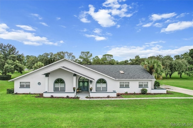 ranch-style home featuring covered porch and a front yard