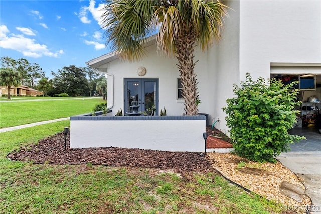 exterior space with french doors and a lawn