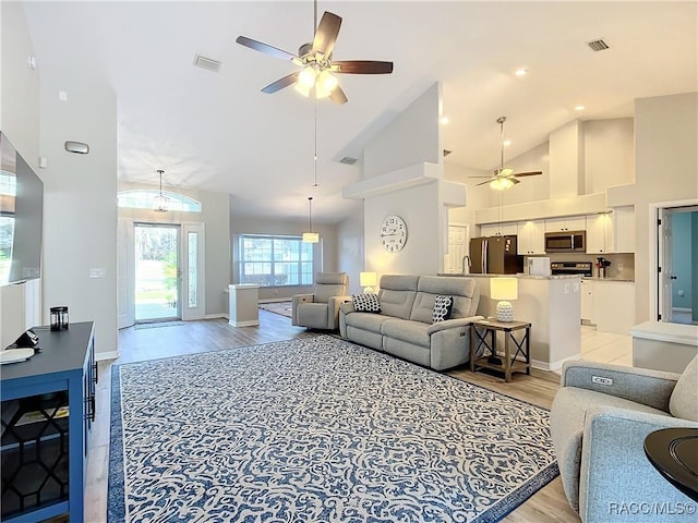 living room featuring high vaulted ceiling, ceiling fan, and light hardwood / wood-style flooring