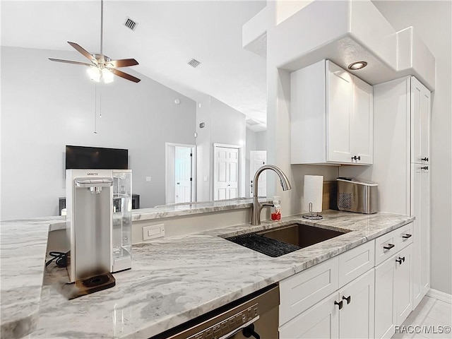 kitchen featuring light stone counters, lofted ceiling, white cabinetry, ceiling fan, and sink