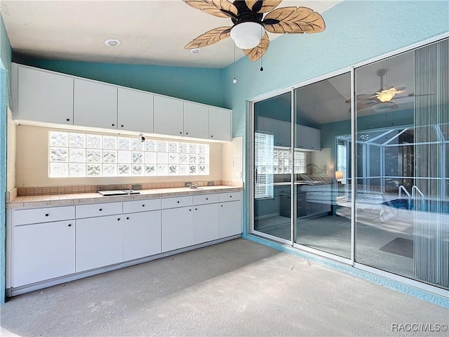 kitchen featuring white cabinets and vaulted ceiling