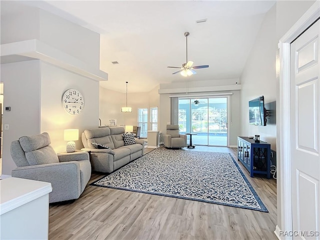 living room featuring lofted ceiling, ceiling fan, and light hardwood / wood-style flooring