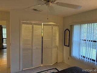 unfurnished bedroom with ceiling fan and light tile patterned floors