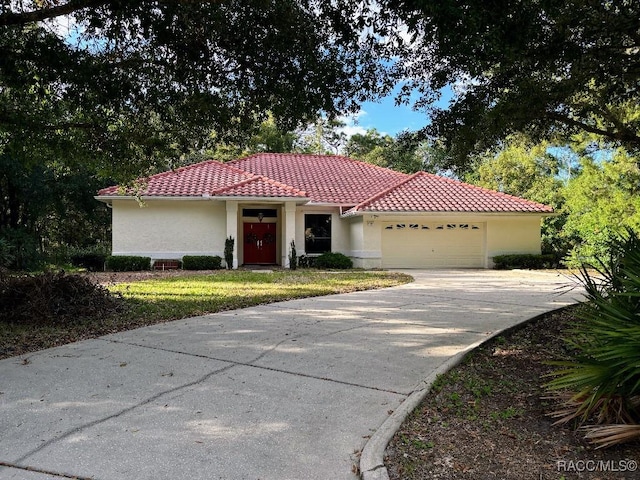 mediterranean / spanish-style house featuring a front yard and a garage