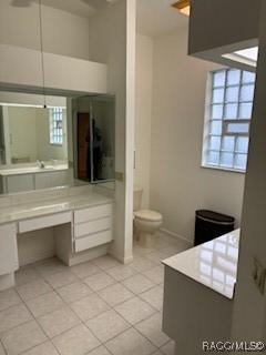 bathroom with tile patterned flooring, toilet, and a wealth of natural light