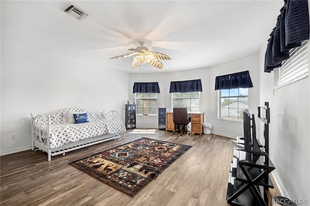 living room with hardwood / wood-style flooring, ceiling fan, and a textured ceiling