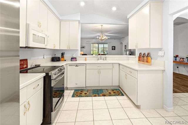 kitchen featuring white cabinets, appliances with stainless steel finishes, vaulted ceiling, and light tile patterned flooring