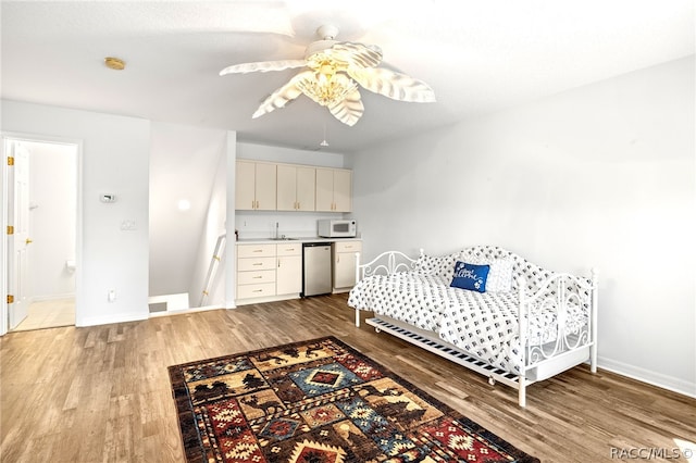 bedroom with ceiling fan, light wood-type flooring, sink, and stainless steel refrigerator