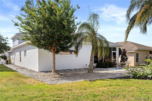 view of home's exterior with a patio and a lawn