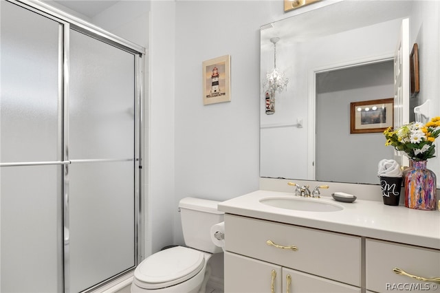 bathroom featuring vanity, toilet, and a shower with shower door