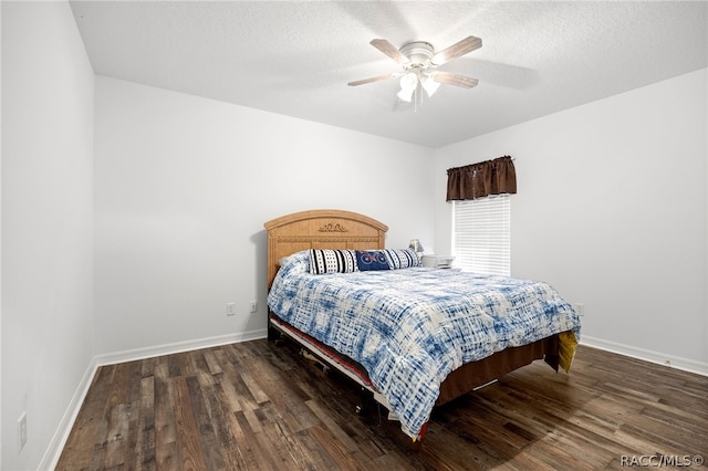 bedroom with a textured ceiling, ceiling fan, and dark wood-type flooring