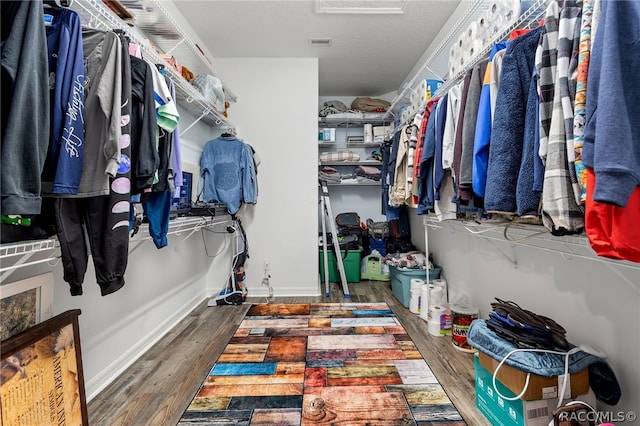 spacious closet featuring dark hardwood / wood-style flooring