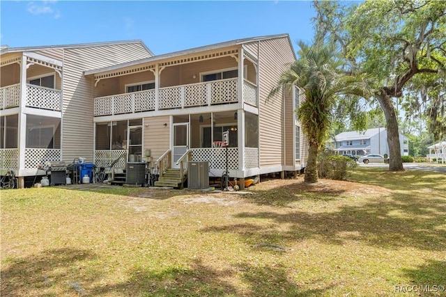rear view of property with a lawn and a balcony