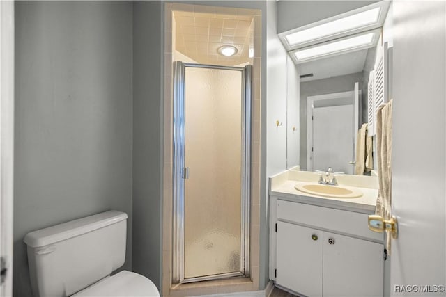 bathroom with a shower stall, vanity, and toilet