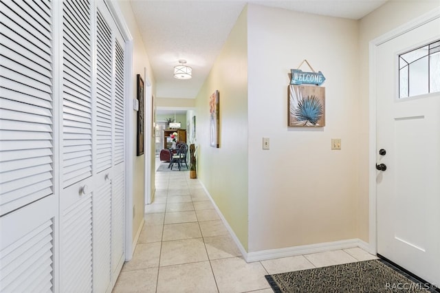 entryway with light tile patterned flooring and a textured ceiling