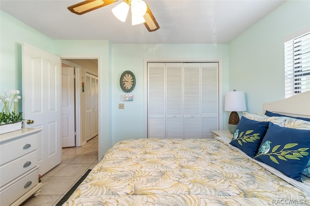 tiled bedroom with a textured ceiling, a closet, and ceiling fan