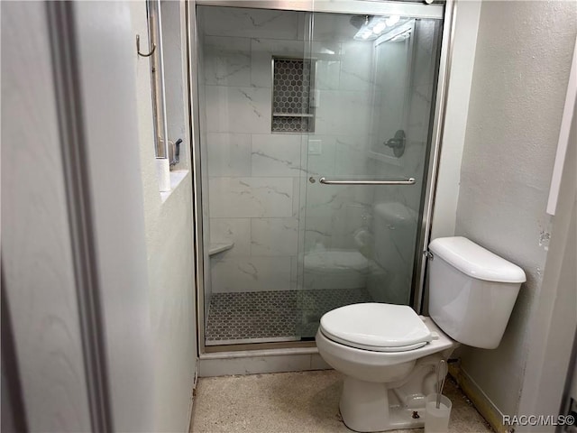 bathroom with a textured wall, speckled floor, a stall shower, and toilet