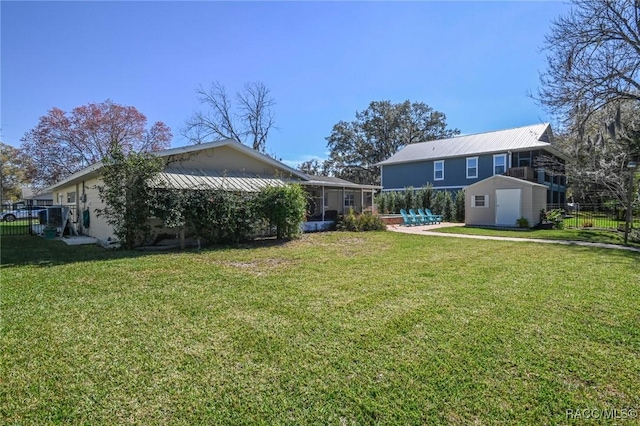 back of house with a yard, a shed, an outdoor structure, and fence