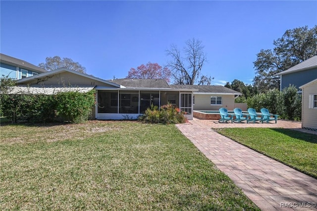 back of house featuring a sunroom, a patio area, and a lawn