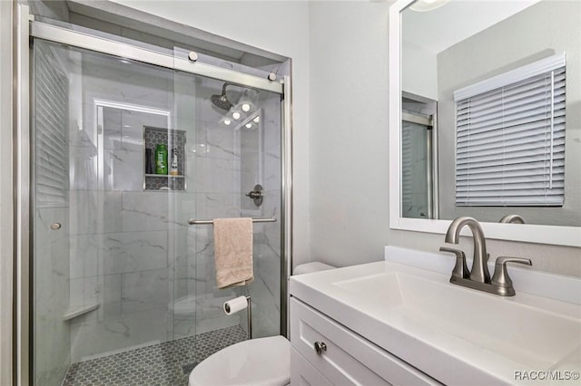 bathroom featuring a marble finish shower, vanity, and toilet