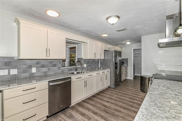 kitchen with dark wood-style flooring, visible vents, backsplash, appliances with stainless steel finishes, and a sink