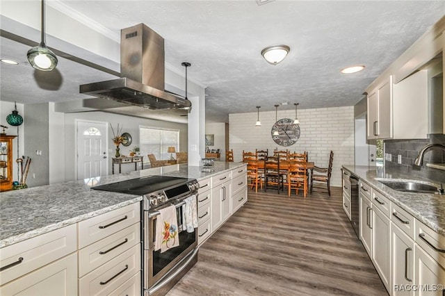 kitchen featuring appliances with stainless steel finishes, dark wood-style flooring, island exhaust hood, a textured ceiling, and a sink