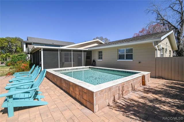 view of swimming pool featuring a sunroom, a patio area, fence, and a hot tub