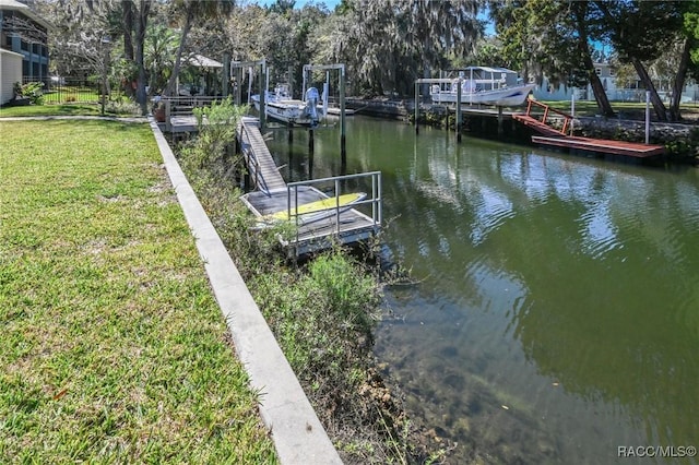 view of dock featuring a water view and a lawn