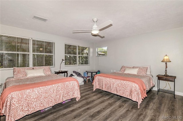 bedroom with a ceiling fan, baseboards, visible vents, and wood finished floors