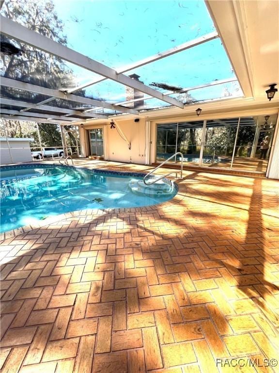 view of swimming pool with a lanai and a patio area