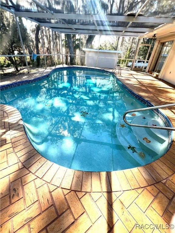 view of pool with a patio and glass enclosure