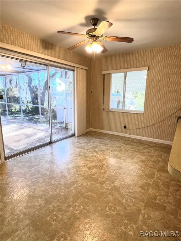 empty room featuring ceiling fan and a wealth of natural light