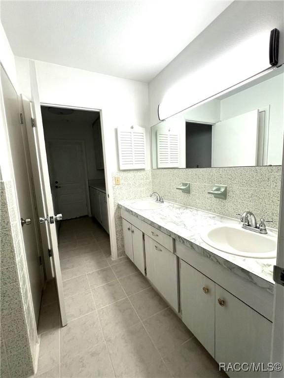 bathroom featuring tile patterned flooring, vanity, and decorative backsplash