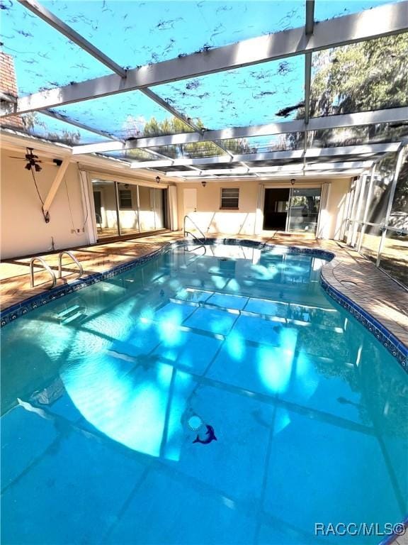 view of pool featuring glass enclosure