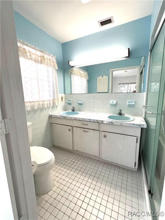 bathroom with tile patterned floors, vanity, toilet, and plenty of natural light