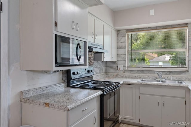 833 Maple Ave, Inverness, FL 34452 - kitchen with black appliances, a sink, under cabinet range hood, and light countertops