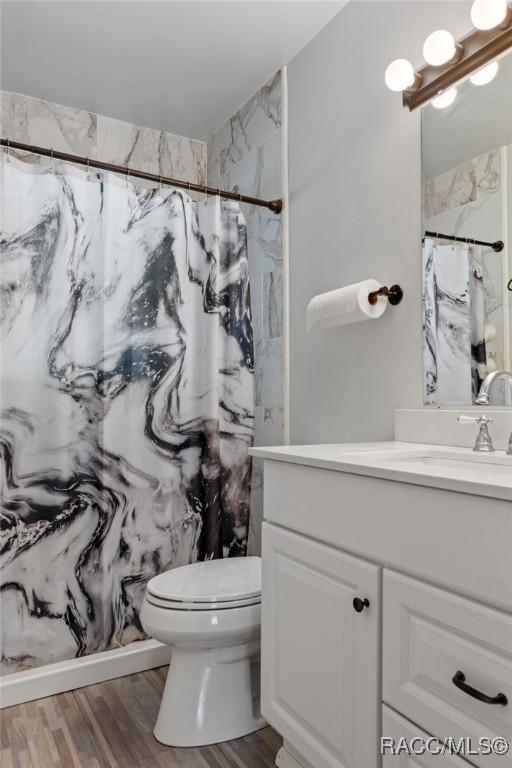 833 Maple Ave, Inverness, FL 34452 - full bath with vanity, toilet, wood finished floors, and a marble finish shower