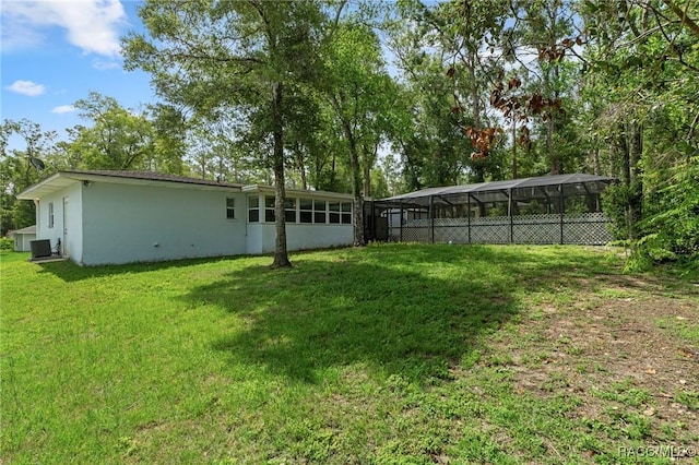833 Maple Ave, Inverness, FL 34452 - rear view of house featuring a detached carport, a lawn, stucco siding, and glass enclosure