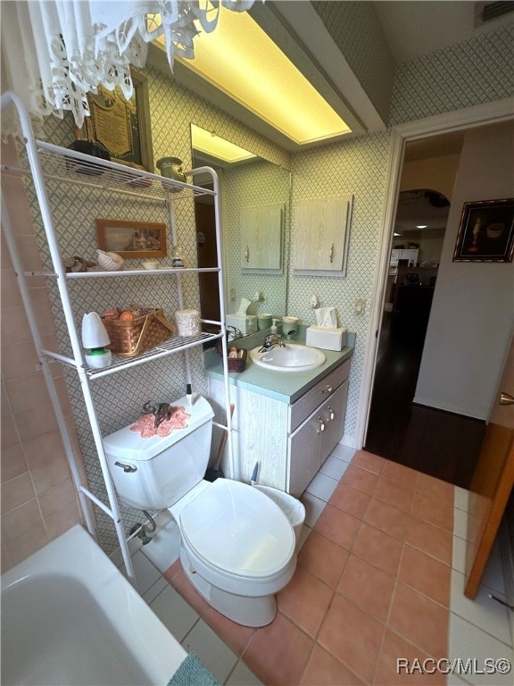 bathroom featuring a bathing tub, tile patterned flooring, vanity, and toilet