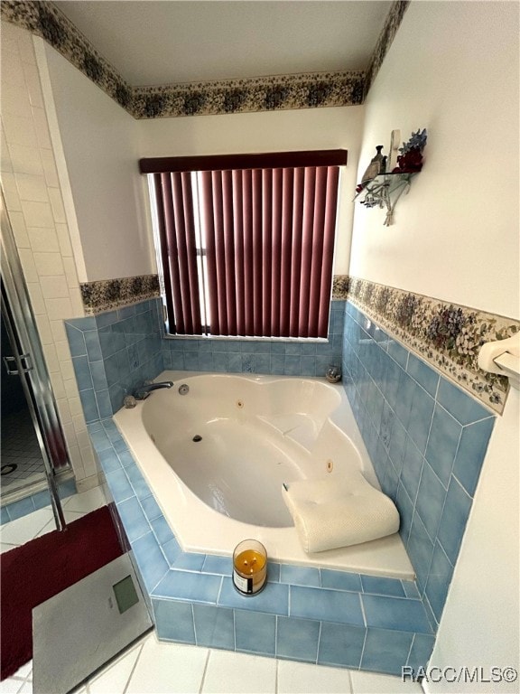 bathroom with tile patterned floors and tiled tub